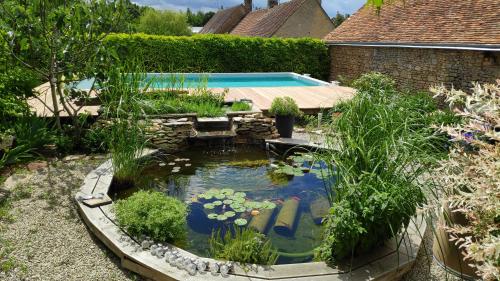 a backyard with a koi pond and a swimming pool at Chambre tout confort à l'étage in Conlie