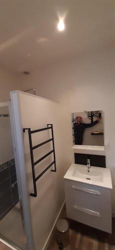 a bathroom with a white sink and a mirror at Chambre tout confort à l'étage in Conlie