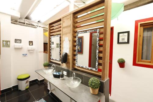 a bathroom with two sinks and two mirrors at Hospedaria da Mama in Sao Paulo