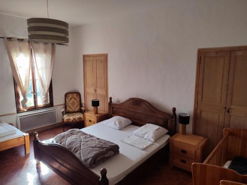 Le CailarにあるMas du Grand Bourryのベッドルーム1室(ベッド1台、椅子、窓付)