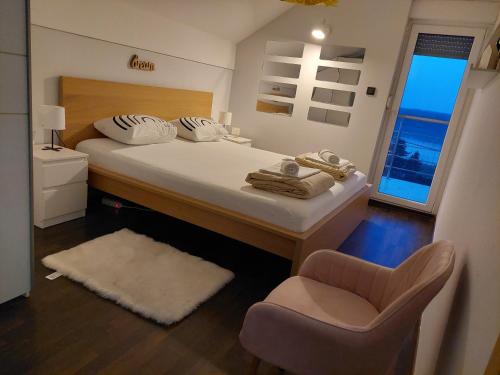 1 dormitorio con 1 cama grande y 1 silla en Ivančica en Aljmaš