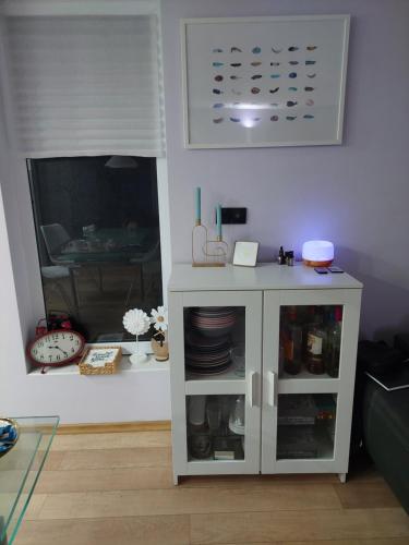 a white cabinet with dishes in it in a living room at Ivančica in Aljmaš