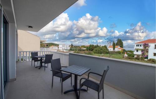 Un balcón con mesas y sillas y un gran ventanal. en Nice Home In Sreser With Jacuzzi, en Sreser