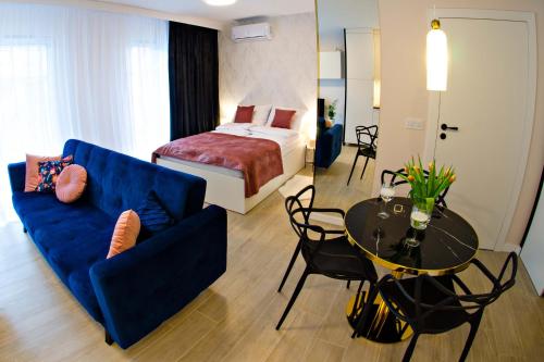 Cette chambre comprend un lit, un canapé bleu et une table. dans l'établissement Cherub Apartment, à Wrocław
