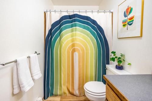 a bathroom with a shower curtain with a rainbow at THE ROGUE WAVE-Beach Access, Ocean Views, Private in Kodiak