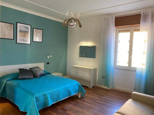 a bedroom with a blue bed and a window at L'Aurora Guest House in Castellammare di Stabia