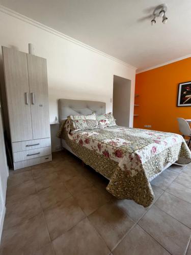 1 dormitorio con cama y pared de color naranja en Palermo Soho Orei en Buenos Aires