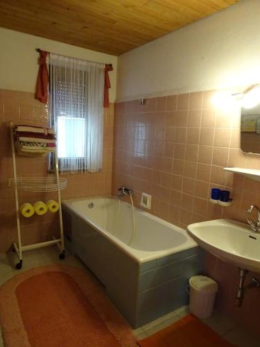 a bathroom with a bath tub and a sink at Ferienwohnung Traudl Singer in Innsbruck