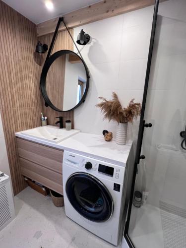 pralka w łazience z umywalką w obiekcie Domek pod lasem „2” w mieście Pasłęk