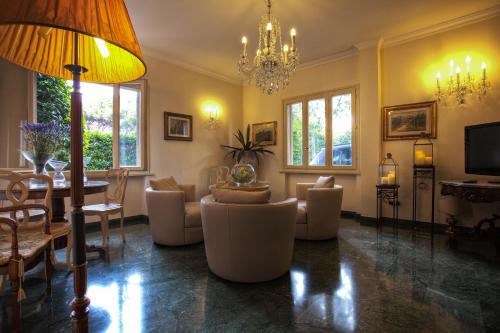 a living room with couches and a chandelier at Hotel Atlantico in Castiglioncello