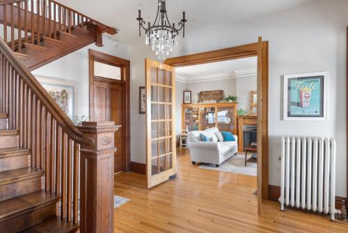 a living room with a staircase and a chandelier at Dubuque's Front Porch, Historic Charmer, Walk Downtown in Dubuque