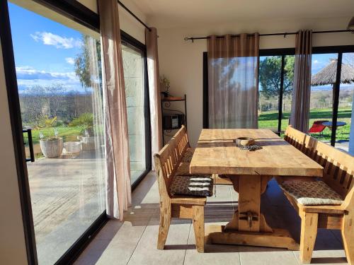 - une table et des chaises en bois dans une chambre avec une grande fenêtre dans l'établissement Villa en Camargue, à Le Cailar