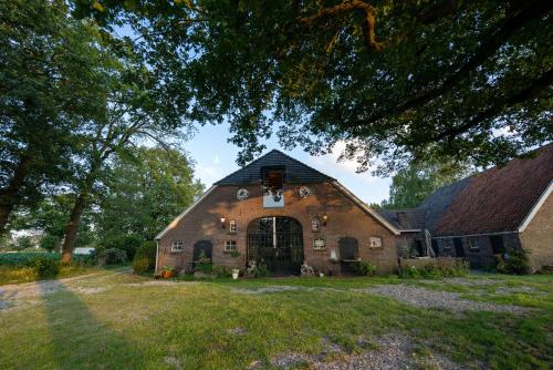 an old brick barn with a large window on it at Stroeckmanhoeve in Neede
