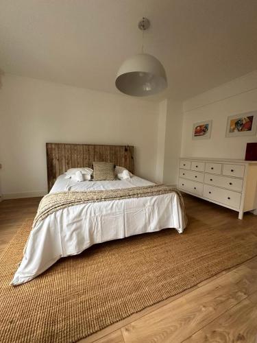 une chambre avec un grand lit et une commode dans l'établissement Romy, à Boulogne-sur-Mer