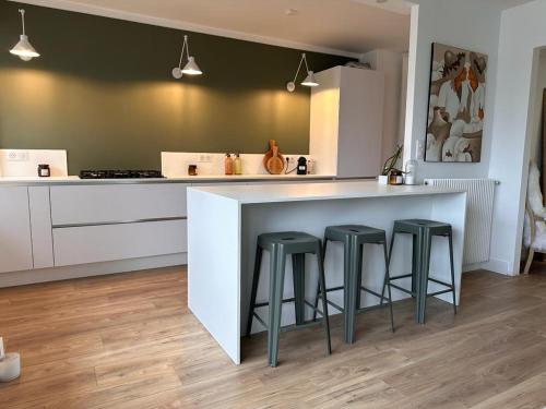 une cuisine avec un comptoir et des tabourets dans une pièce dans l'établissement Romy, à Boulogne-sur-Mer