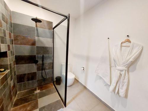 uma casa de banho com um chuveiro e um WC. em L'Hédone, hôtel de charme em Ouagadougou