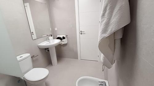 Baño blanco con aseo y lavamanos en Kiana Mirador Jerez con parking, en Jerez de la Frontera