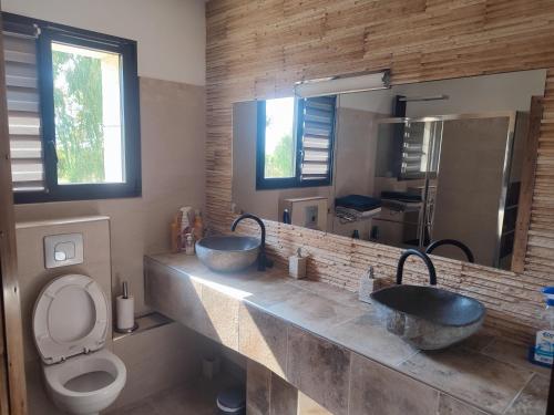 une salle de bain avec deux lavabos et un WC dans l'établissement Villa en Camargue, à Le Cailar
