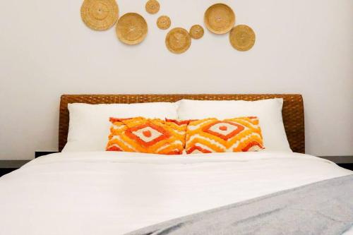 a bed with twocoins on the wall and two pillows at PREMIUM Tanjung Jara Cottage - with indoor pool in Dungun