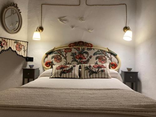 モンテフリオにあるLas casillas de la Villa ALEGRÍASのベッドルーム(花のヘッドボード付きの大型ベッド1台付)