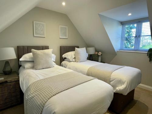 two beds in a room with a attic at Lavender Lodge Bourton in Bourton on the Water