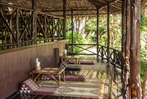 a porch of a house with a table and benches at Shiralea Backpackers Resort in Haad Yao