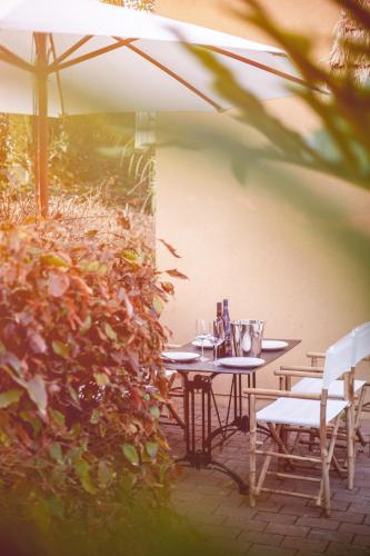 a patio with a table and chairs and an umbrella at Dolphin Village - Sea Resort By Ran Hotels in Shave Ẕiyyon