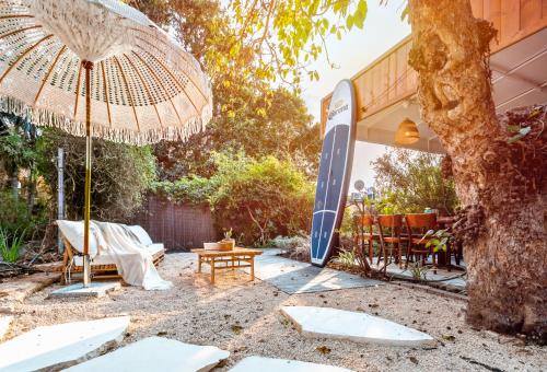 a patio with an umbrella and a table at Dolphin Village - Sea Resort By Ran Hotels in Shave Ẕiyyon