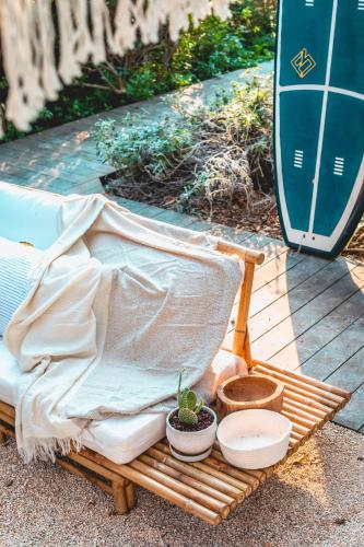 a blanket and potted plants sitting on a wooden bench at Dolphin Village - Sea Resort By Ran Hotels in Shave Ẕiyyon