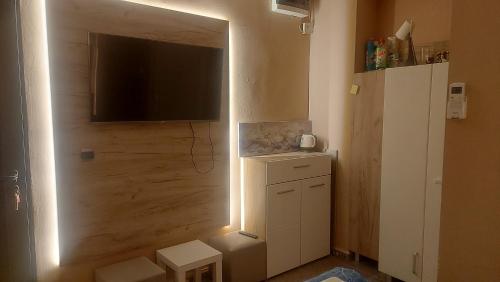 a living room with a television and a cabinet with a light at Skopje Apartment in Skopje