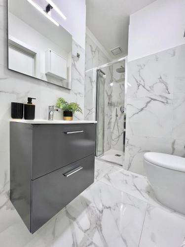 a white bathroom with a sink and a toilet at Corso Venezia in Mestre