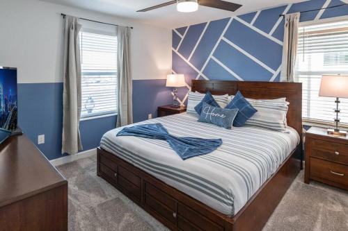 a bedroom with a large bed with blue walls at Luxury 9BR Villa @ Storey Lake Resort Near Disney in Kissimmee