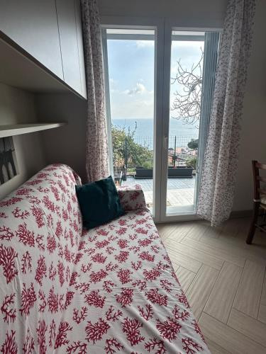 a bedroom with a bed and a view of the ocean at Casa del sasso in Bergeggi