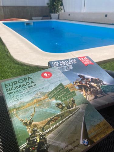 una revista sentada en una mesa junto a una piscina en Chalet con piscina en Simancas