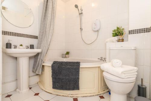 een badkamer met een bad, een toilet en een wastafel bij Whetstone House in Ketteringham