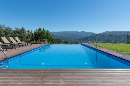 a swimming pool with a view of the mountains at Casas de Tourim in Arcos de Valdevez