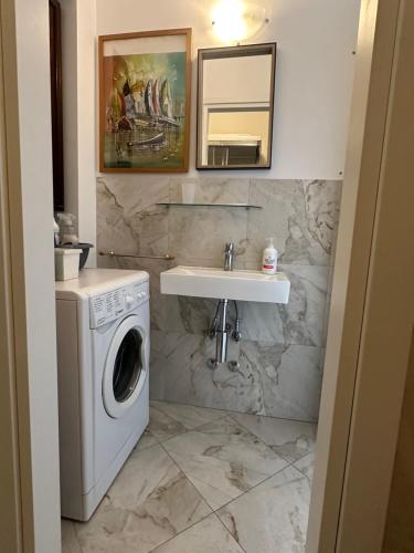 a bathroom with a washing machine and a sink at Casa del sasso in Bergeggi