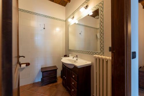 bagno con lavandino e specchio di Villa Collemancio la soleggiata a Bevagna