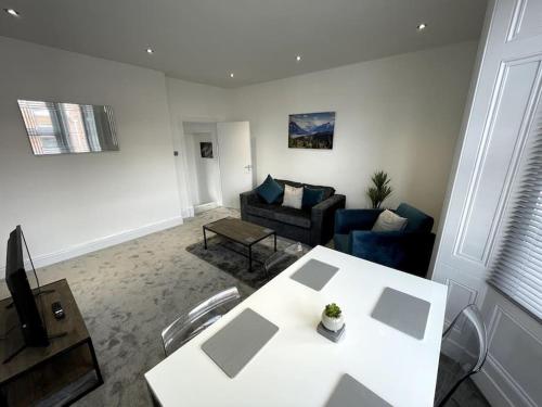a living room with a table and a couch at Priestley Apartments Apt 1 in Nantwich