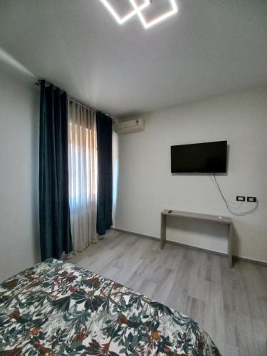 um quarto com uma cama e uma televisão de ecrã plano em L.ADY HOME em Bolonha