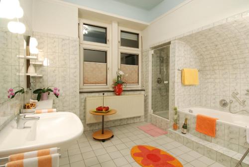 a white bathroom with a tub and a sink at Gästehaus & Weingut Clüsserath-Weiler in Trittenheim