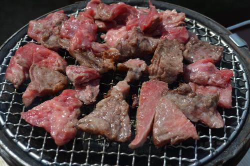 a bunch of meat cooking on a grill at Guest House Isa in Motobu