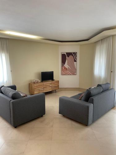 a living room with two couches and a television at Relax Beach Home - Costa de Caparica - Sea View in Costa da Caparica