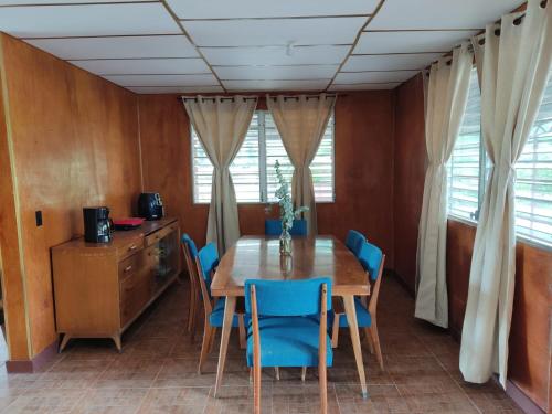 une salle à manger avec une table en bois et des chaises bleues dans l'établissement Las Nubes Hostal, 