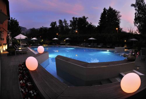 a large swimming pool at night with lights at Hotel Florida in Levico Terme