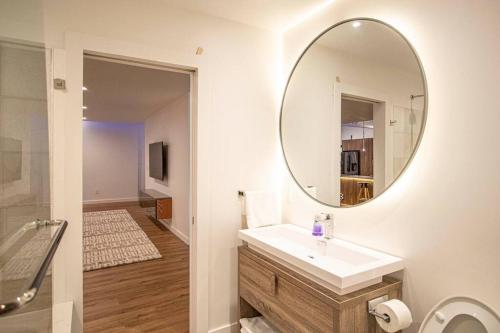 a bathroom with a sink and a mirror at Modern Living in Kirkland in Kirkland
