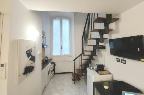 un salon avec un escalier et une télévision dans l'établissement Corso Genova - Milano Navigli, à Milan