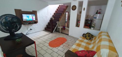 a living room with a couch and a fan at Casa Caiçara Centro in Paraty