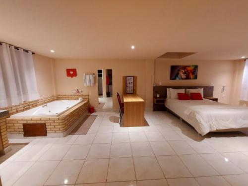 um quarto com uma banheira e uma cama e uma cama e uma casa de banho em Hotel Vila Suíça 1818 em Nova Friburgo