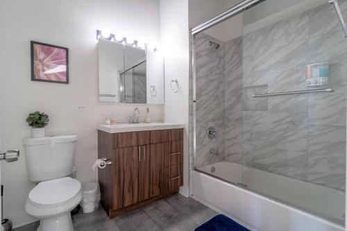 a bathroom with a shower and a toilet and a sink at McCormick Place with city view 2br/2ba - optional Parking & Gym in Chicago